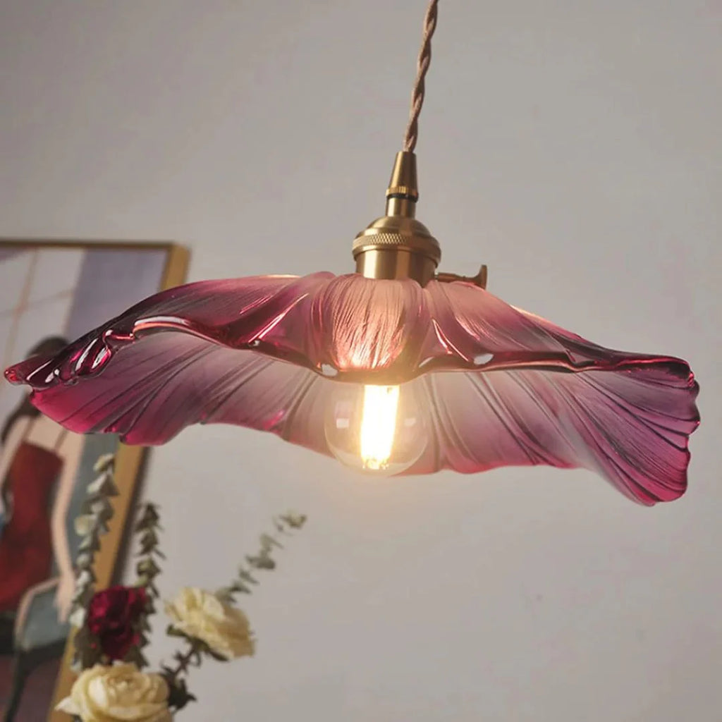 Floral-patterned pendant light with purple glass shade on a neutral background