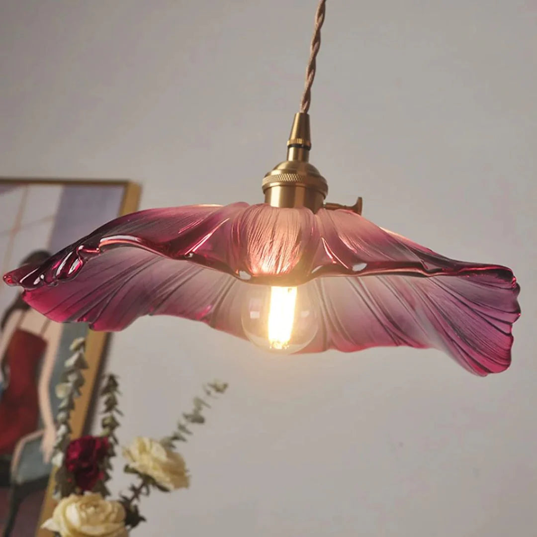 Floral-patterned pendant light with purple glass shade on a neutral background