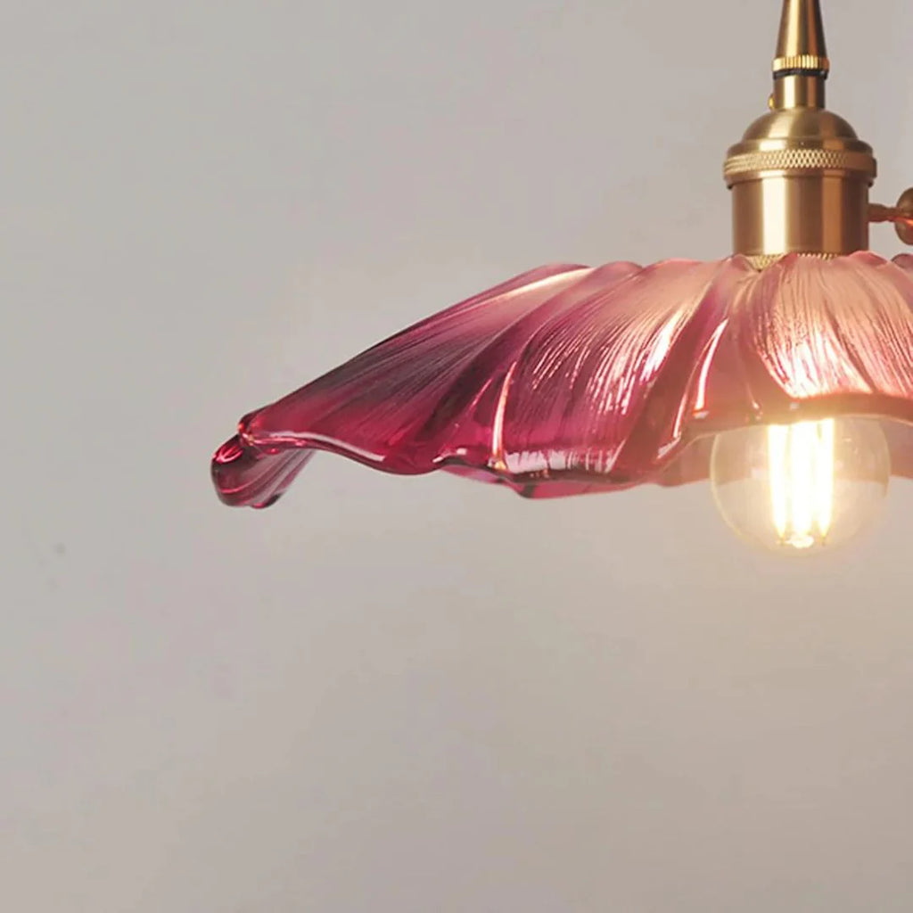 Purple glass pendant light with gold fixture on a plain background