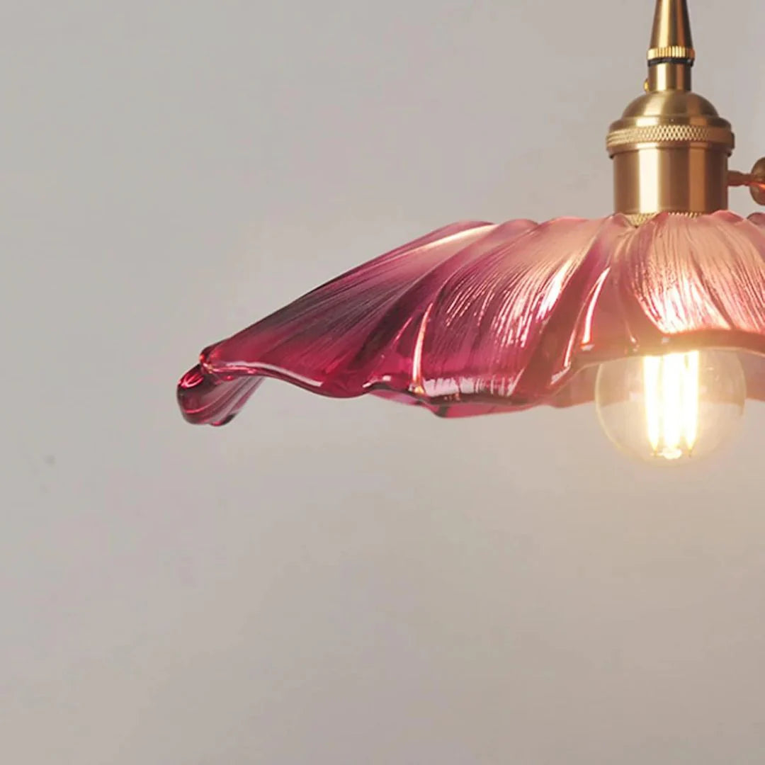 Purple glass pendant light with gold fixture on a plain background