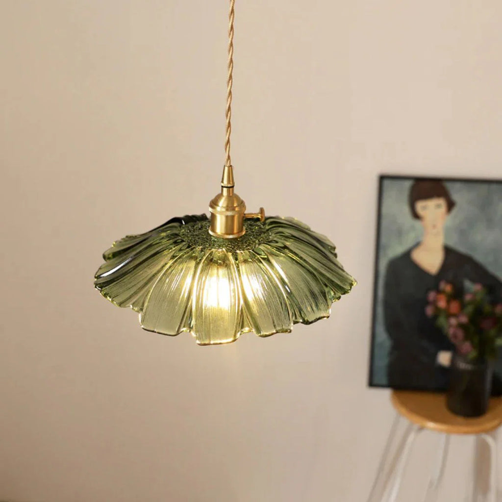 Decorative pendant light with a floral glass shade in a room setting.