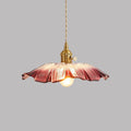 Pendant light with purple glass shade and gold fixture on a grey background