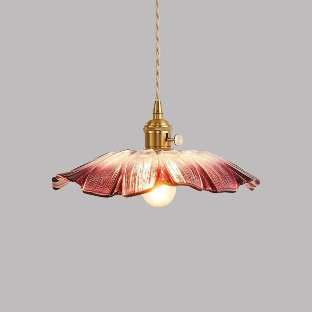 Pendant light with purple glass shade and gold fixture on a grey background