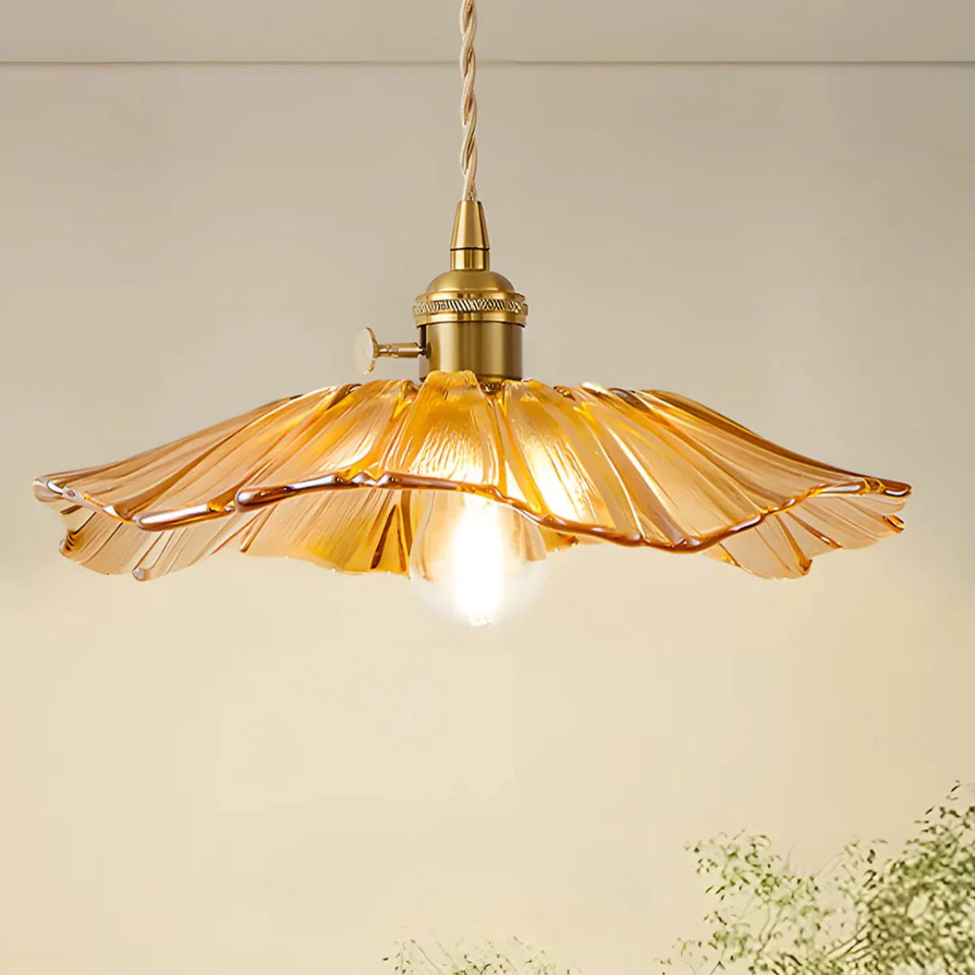 Vintage-style pendant light with an amber finish and ribbed glass shade on a neutral background.