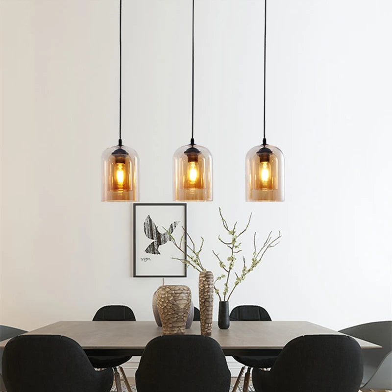 Modern dining room with pendant lights, table, and chairs.