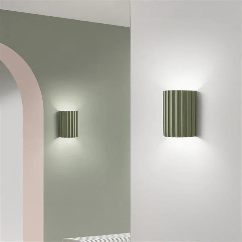 Two cylindrical wall lights on a white wall.