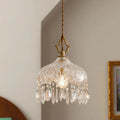Crystal chandelier hanging against a neutral wall with a framed picture.