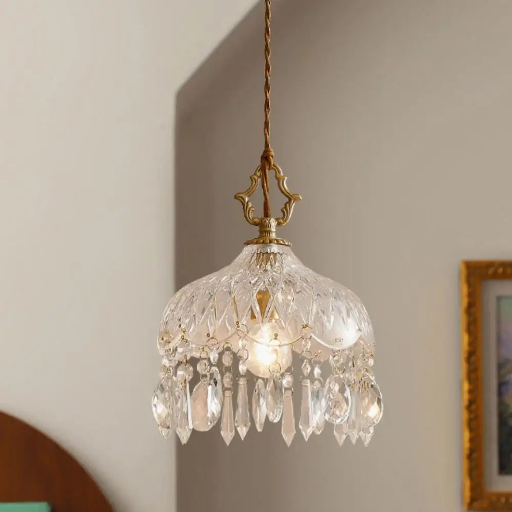 Crystal chandelier hanging against a neutral wall with a framed picture.