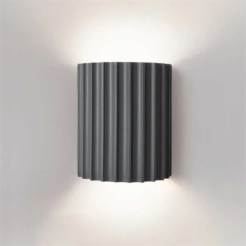 Wall-mounted light fixture with ribbed design on a plain wall