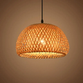 Woven bamboo pendant light with a warm glow on a beige background