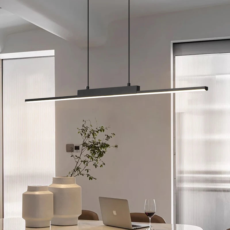 Modern office desk with long pendant light illuminating overhead