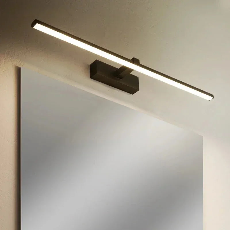 Modern wall-mounted light fixture above a mirror on a neutral wall.