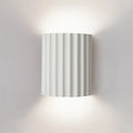 Wall-mounted light fixture with striped design on a plain wall