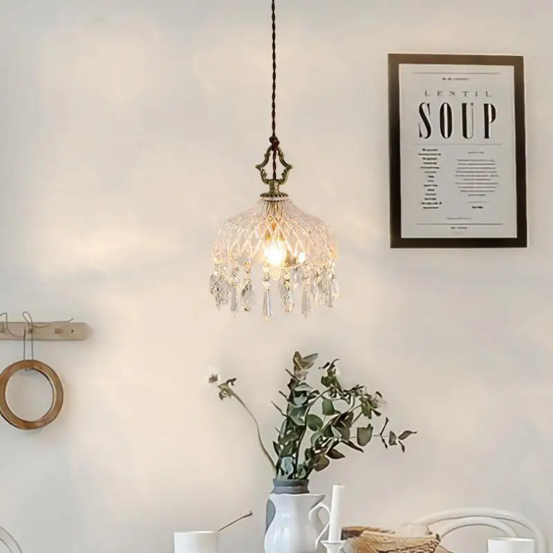 Crystal pendant light fixture in a room with a 'Lentil Soup' poster on the wall.