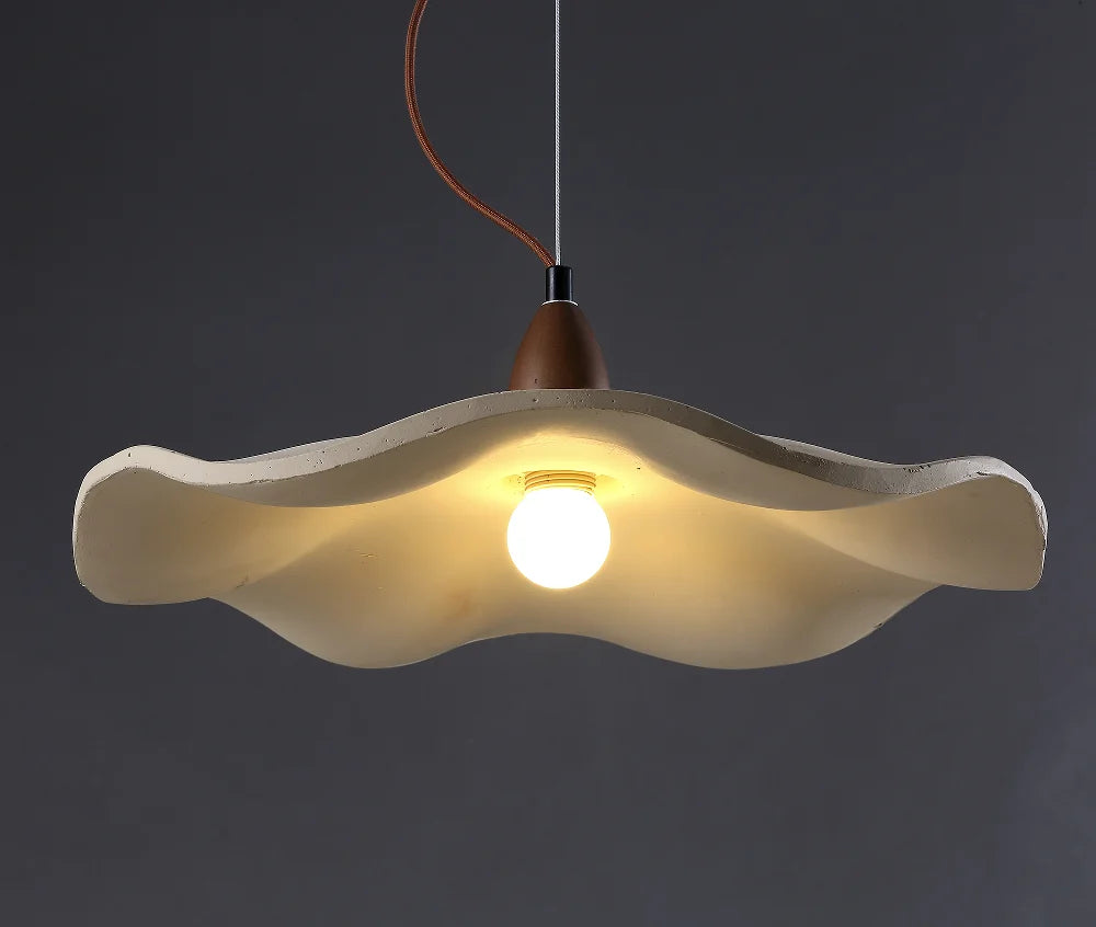 Modern pendant light with a wavy design on a dark background