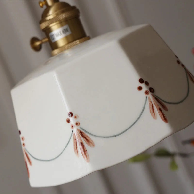 Decorative lampshade with floral patterns and a gold fixture on a white background