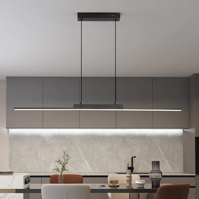 Modern kitchen with grey cabinets, pendant light, and marble backsplash.