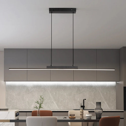 Modern kitchen with grey cabinets, pendant light, and marble backsplash.