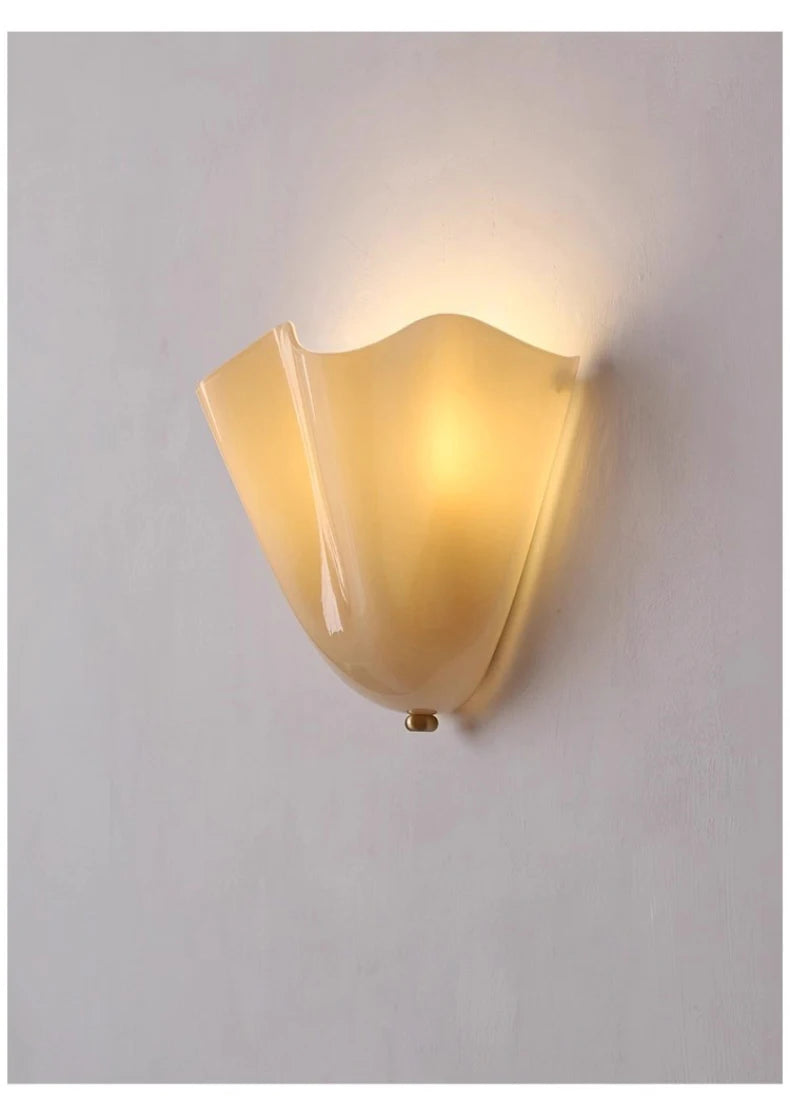 Milky white glass wall sconce illuminating a beige background