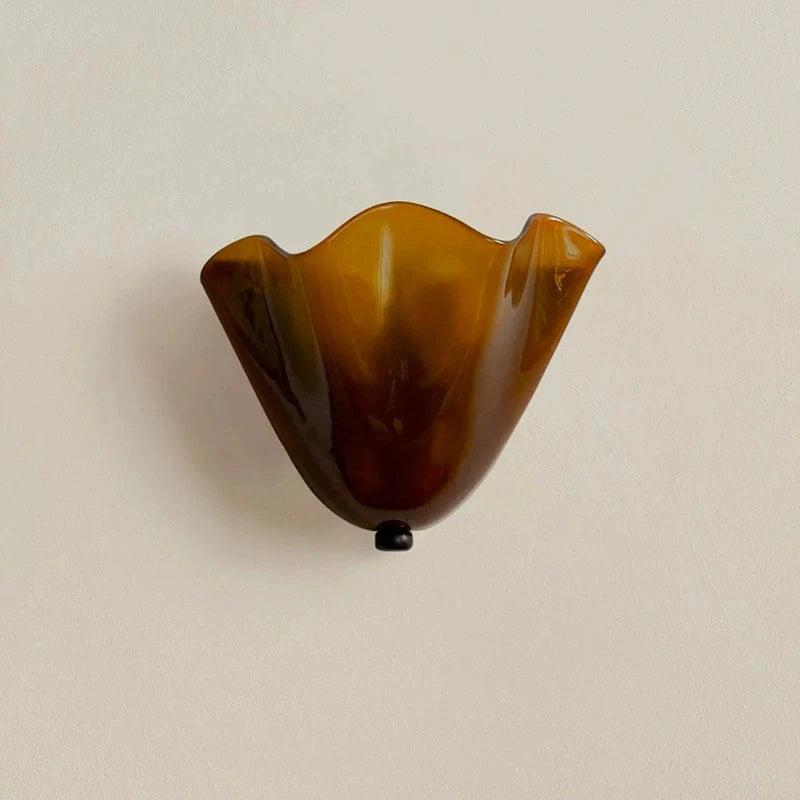 Amber glass wall sconce on a beige background