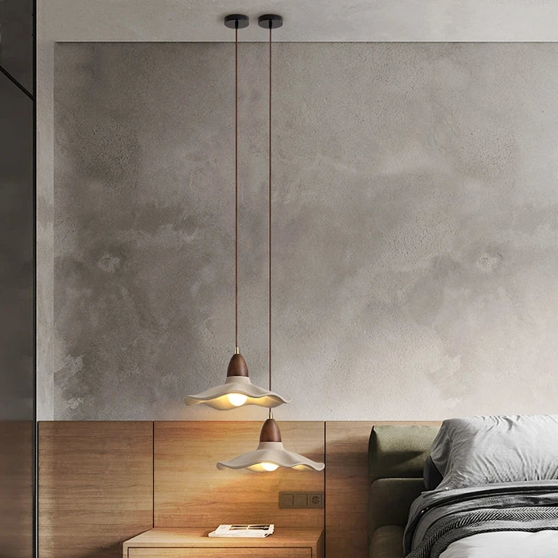 Modern bedroom with pendant lights and a concrete wall.