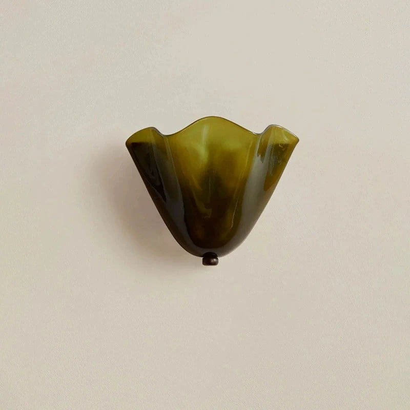 Green glass wall sconce on a beige background