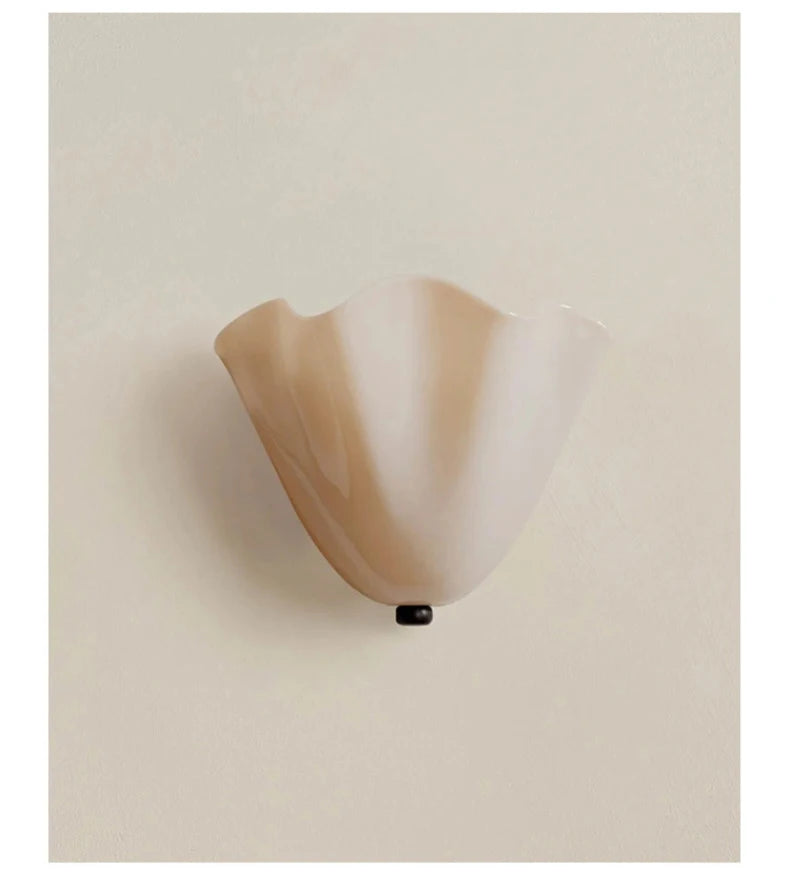 Milky white glass wall sconce on a beige background
