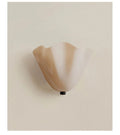 Milky white glass wall sconce on a beige background
