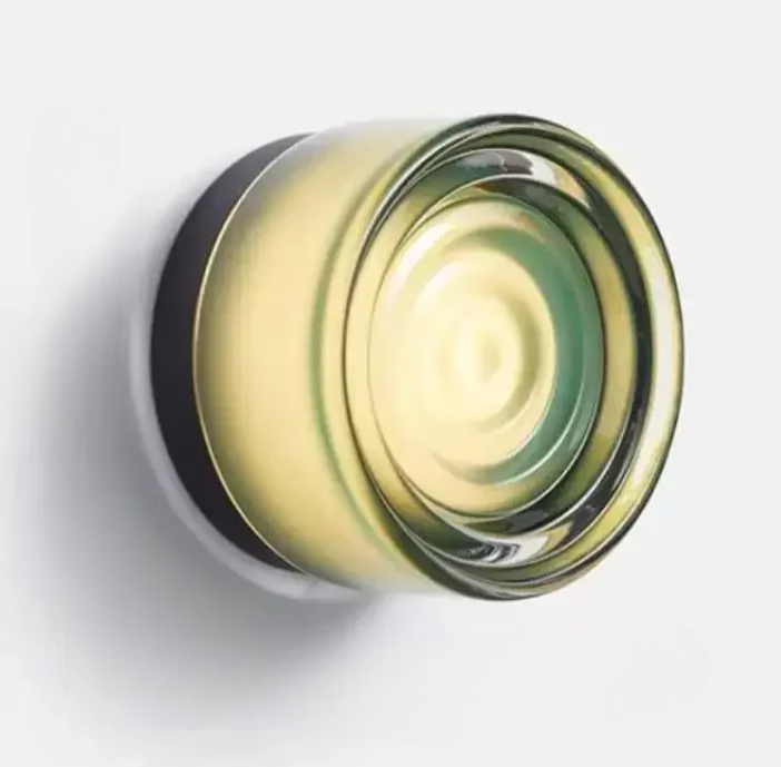 Emerald circular glass wall sconce on a plain white background
