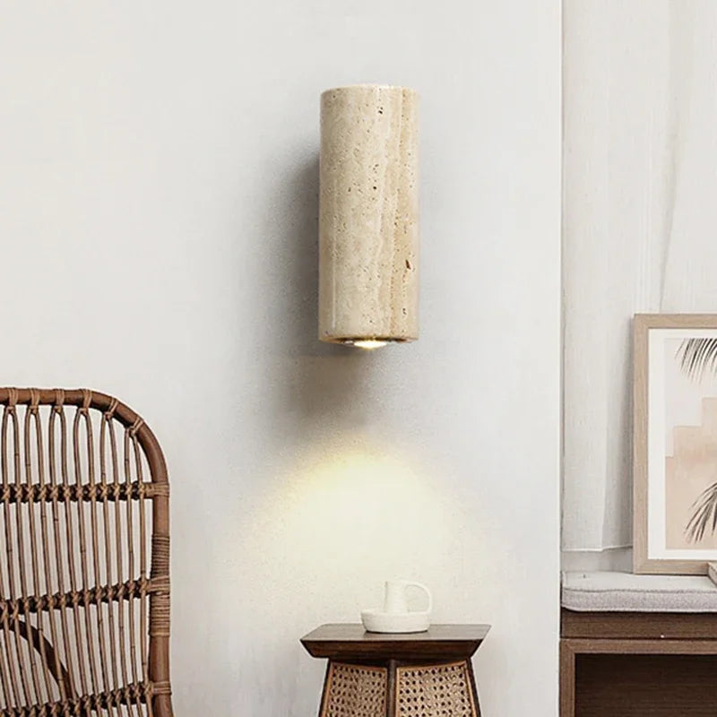 Wall-mounted cylindrical light fixture in a room setting.