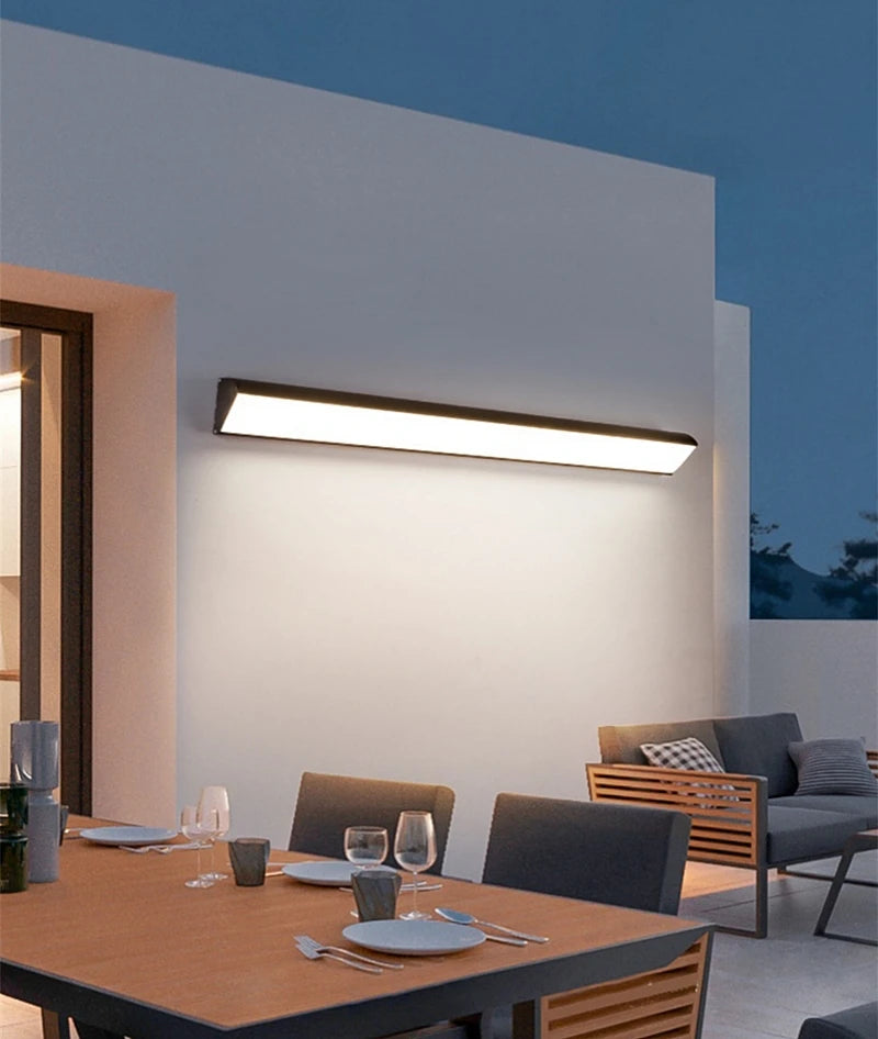 Modern outdoor dining area with a wall-mounted light fixture.