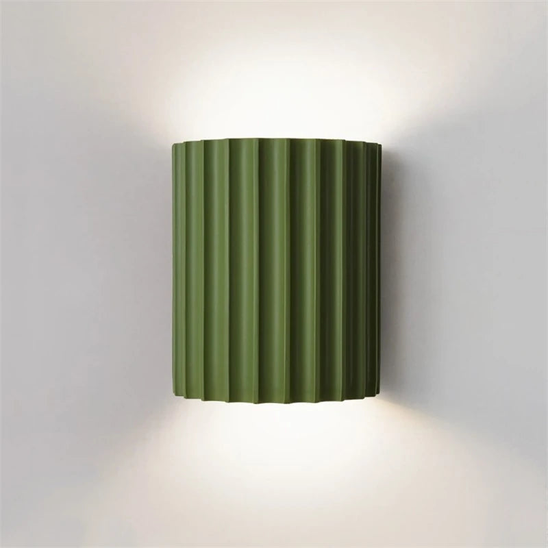 Green wall-mounted light fixture on a gray wall