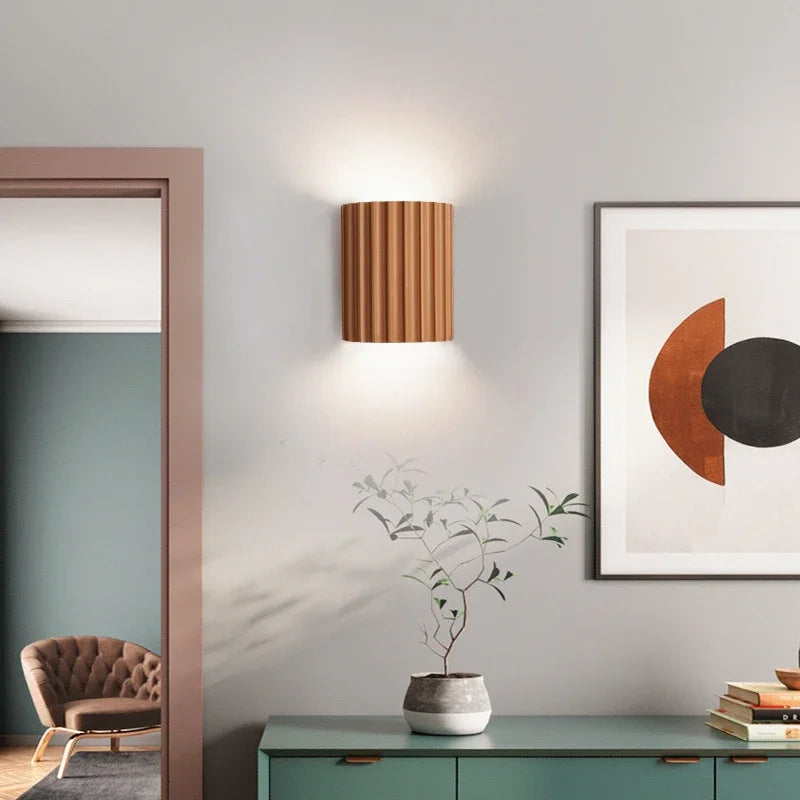 Modern interior design with a lamp, plant, and framed artwork on a wall.