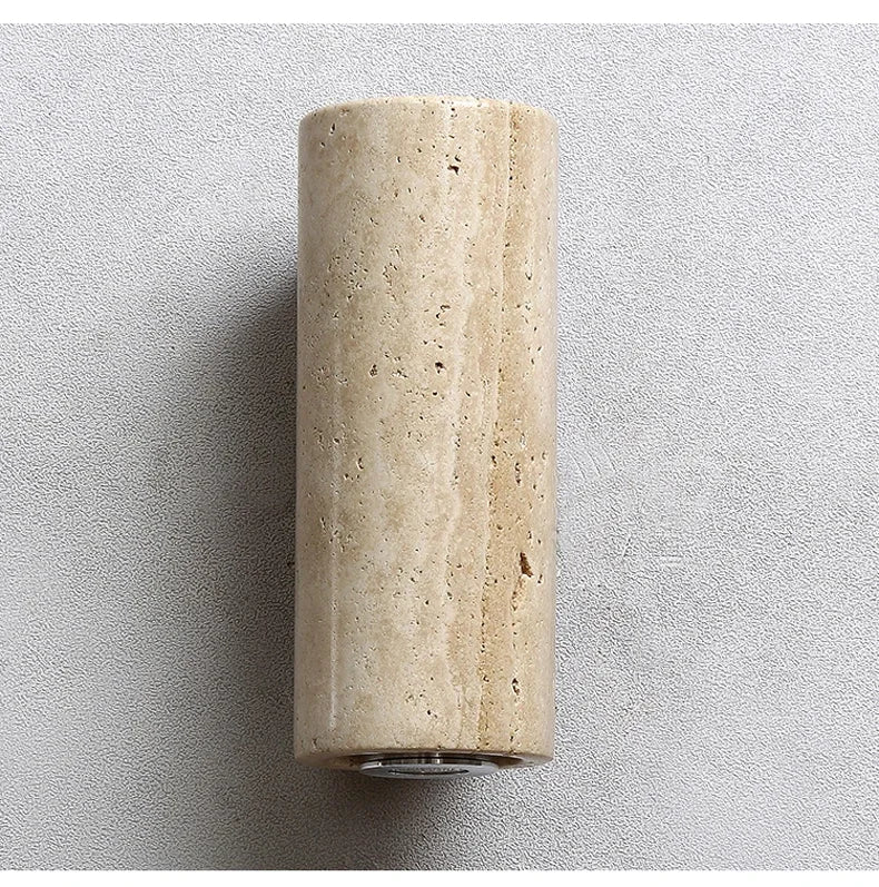 Beige travertine cylindrical wall sconce on a light grey background
