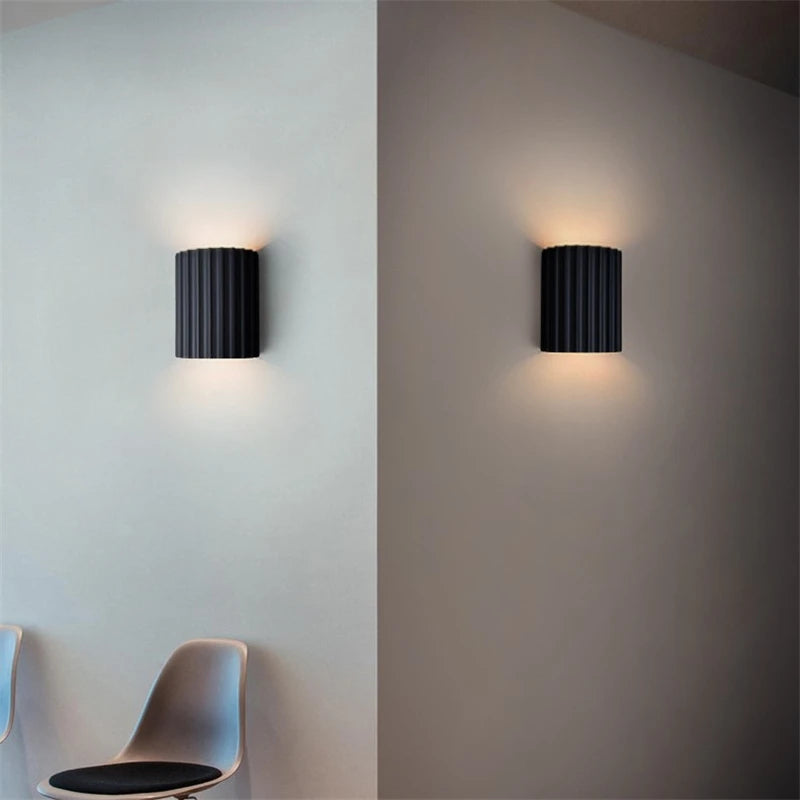 Grey wall-mounted light fixture on a white and gray wall.