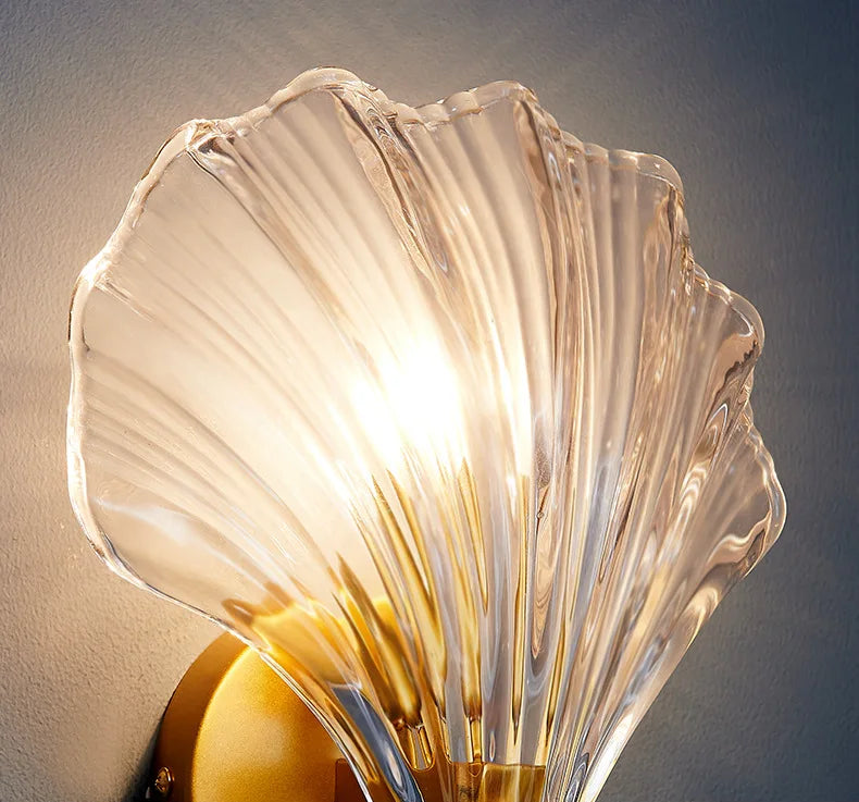 Decorative wall sconce with a scalloped glass shade on a neutral background
