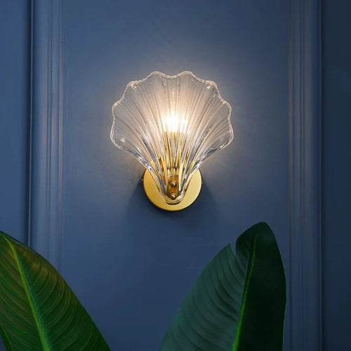Glass shell wall sconce illuminating grey wall 