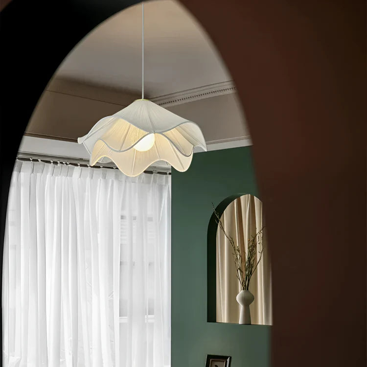 Floral pendant light fixture in a room with a mirror and white curtains.