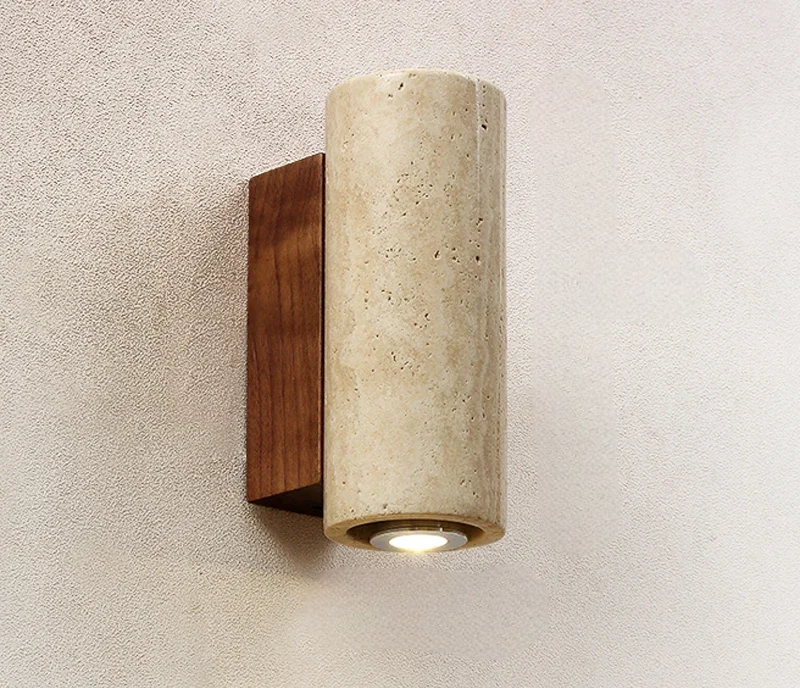 Cylindrical wall light fixture with wooden base on a textured wall