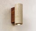 Cylindrical wall light fixture with wooden base on a textured wall